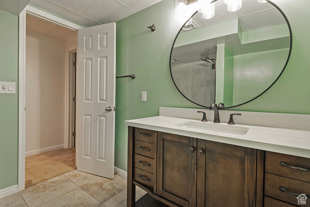 Bathroom with vanity, tile patterned flooring, and a textured ceiling