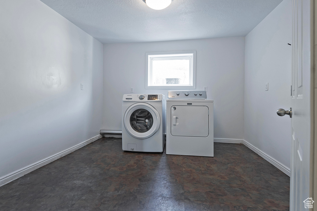 Laundry area featuring washer and clothes dryer and a textured ceiling