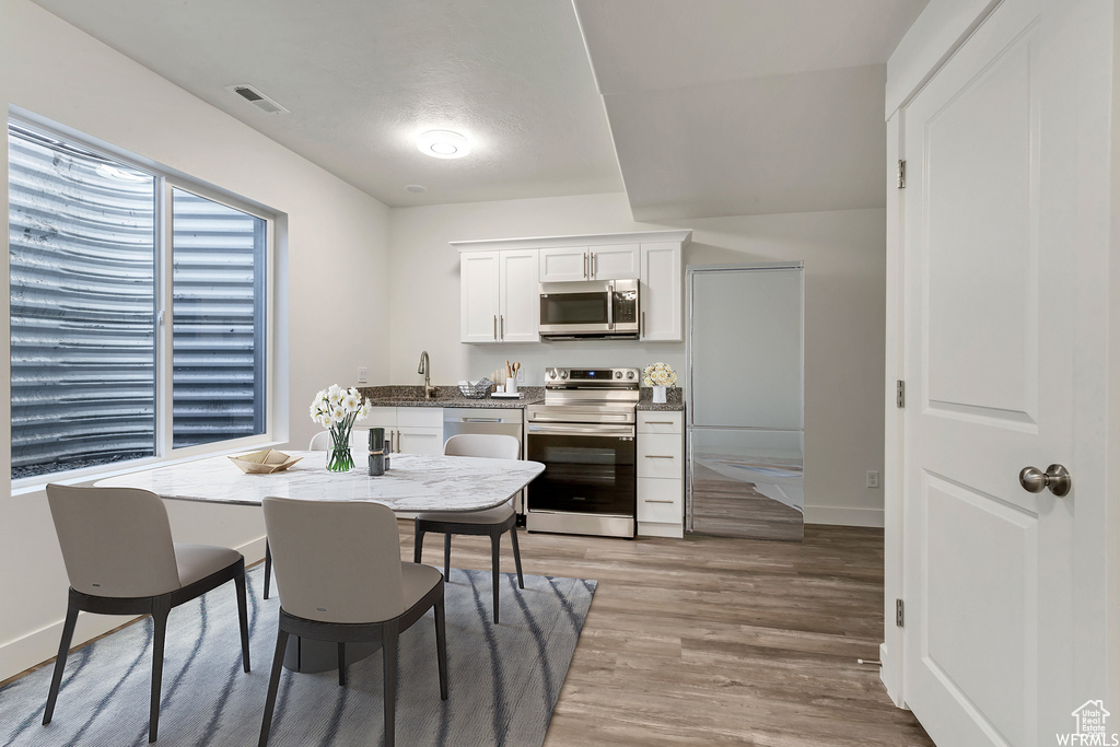 Dining space with light hardwood / wood-style flooring