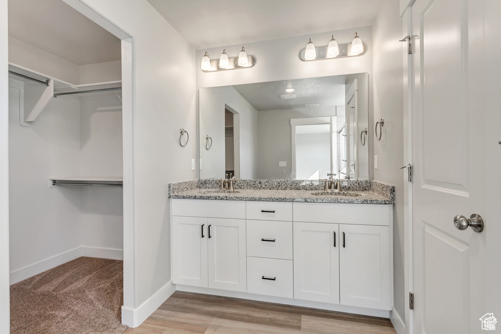 Bathroom featuring wood-type flooring and double sink vanity