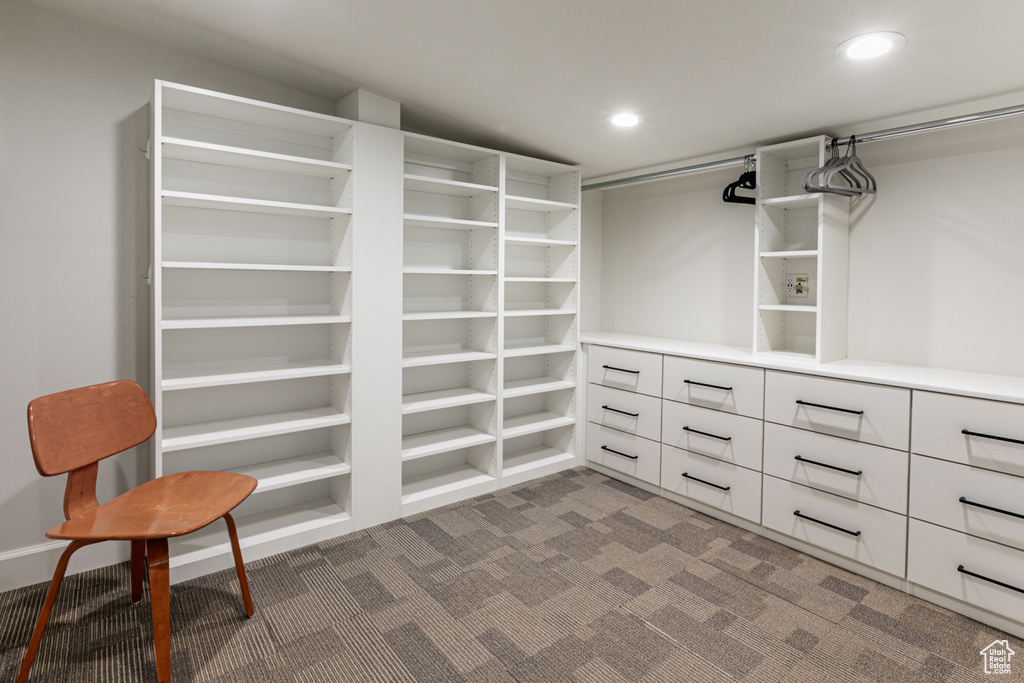 Walk in closet featuring dark carpet