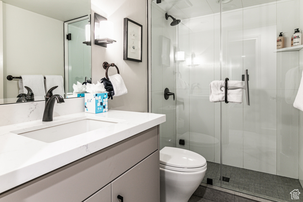 Bathroom with toilet, vanity, and an enclosed shower