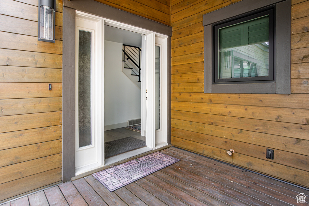 View of exterior entry featuring a wooden deck