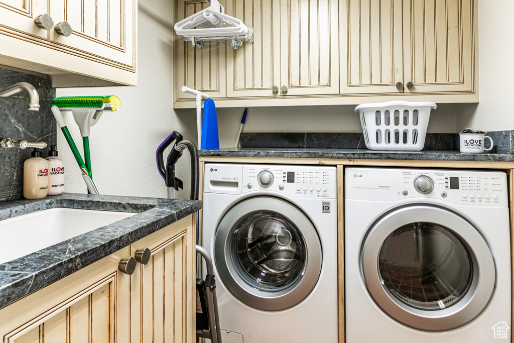 Laundry area with sink, cabinets, and independent washer and dryer