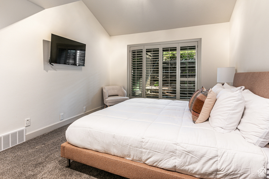 Carpeted bedroom with lofted ceiling