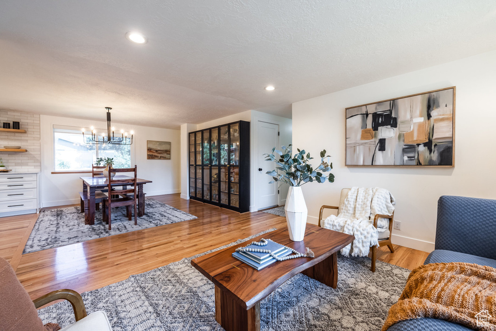 Living room featuring an inviting chandelier and light hardwood / wood-style floors