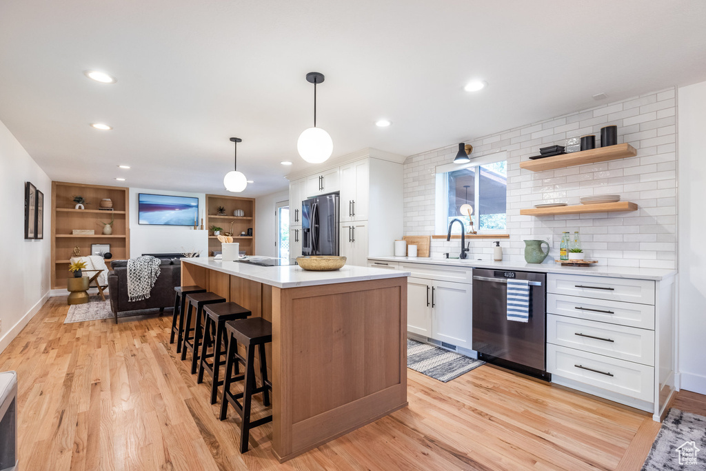 Kitchen featuring stainless steel appliances, light hardwood / wood-style flooring, and white cabinets