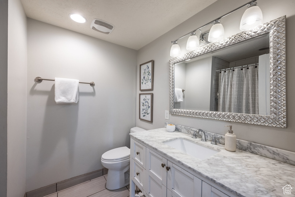 Bathroom with vanity, tile patterned flooring, and toilet