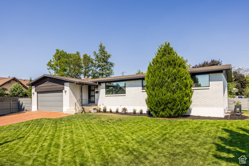 Ranch-style home with a garage and a front lawn