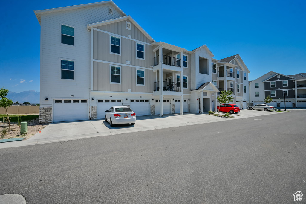 View of front of property featuring a garage and a balcony