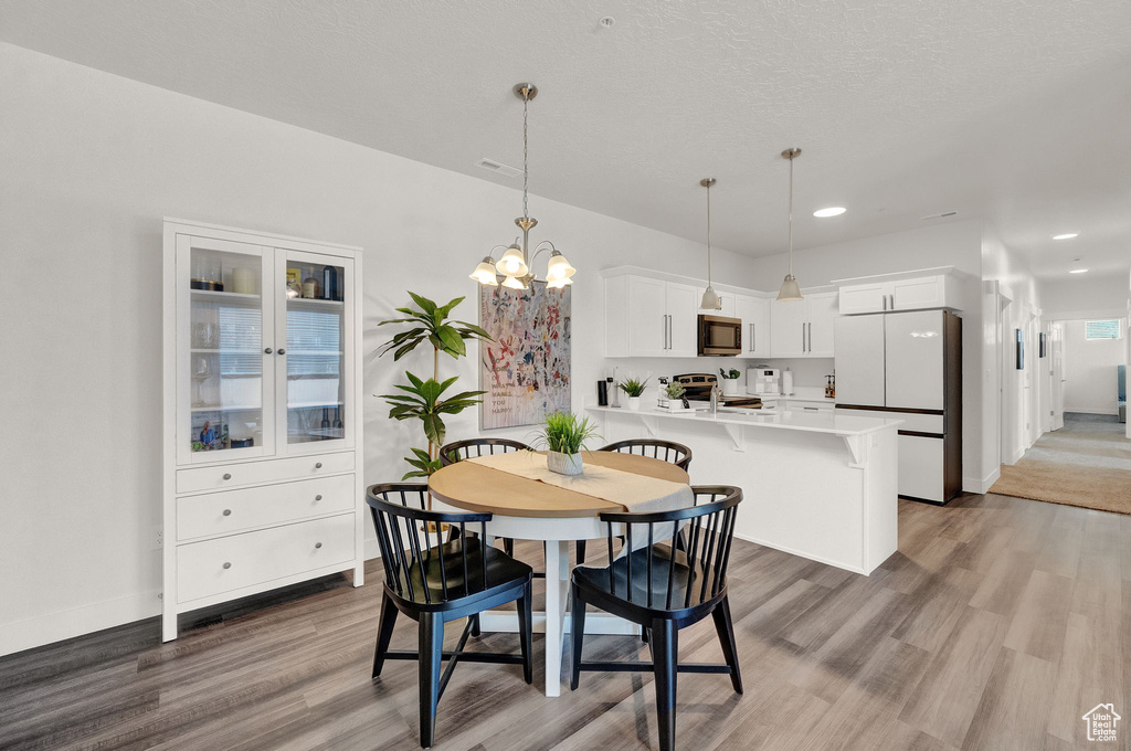 Dining space featuring hardwood / wood-style flooring and an inviting chandelier