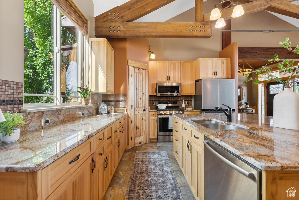 Kitchen featuring sink, dark tile patterned floors, a wealth of natural light, and stainless steel appliances