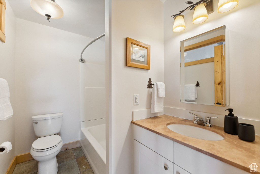 Full bathroom with tile patterned floors, vanity, toilet, and shower / tub combination