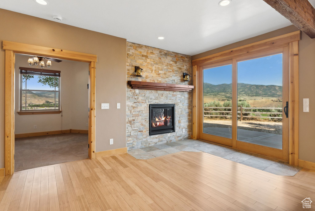 Unfurnished living room with a fireplace, light hardwood / wood-style flooring, and a wealth of natural light