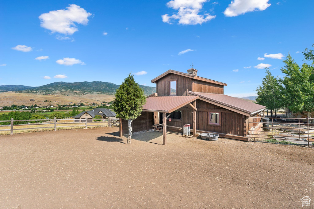 View of front of home with a mountain view and a rural view