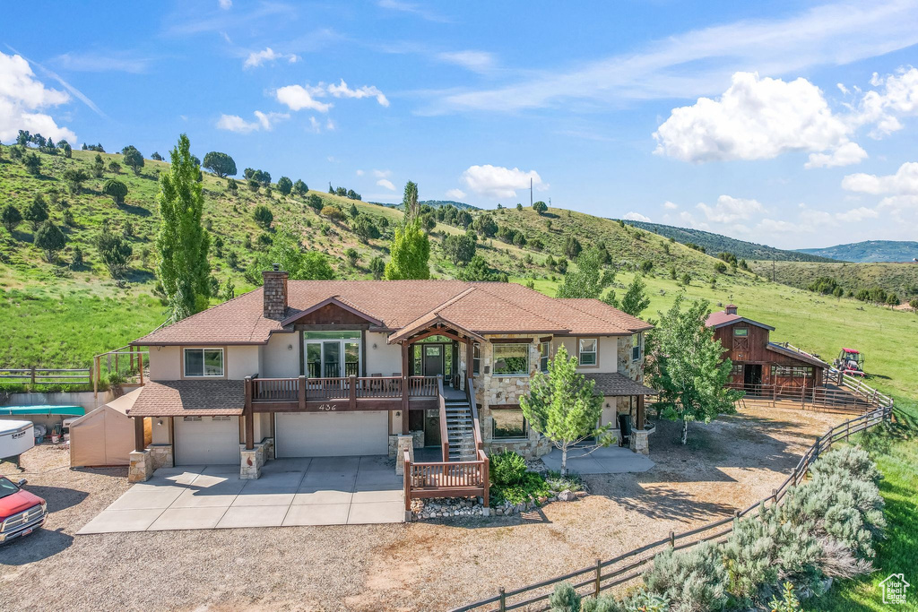 View of front of property featuring a garage, a patio, and a swimming pool side deck