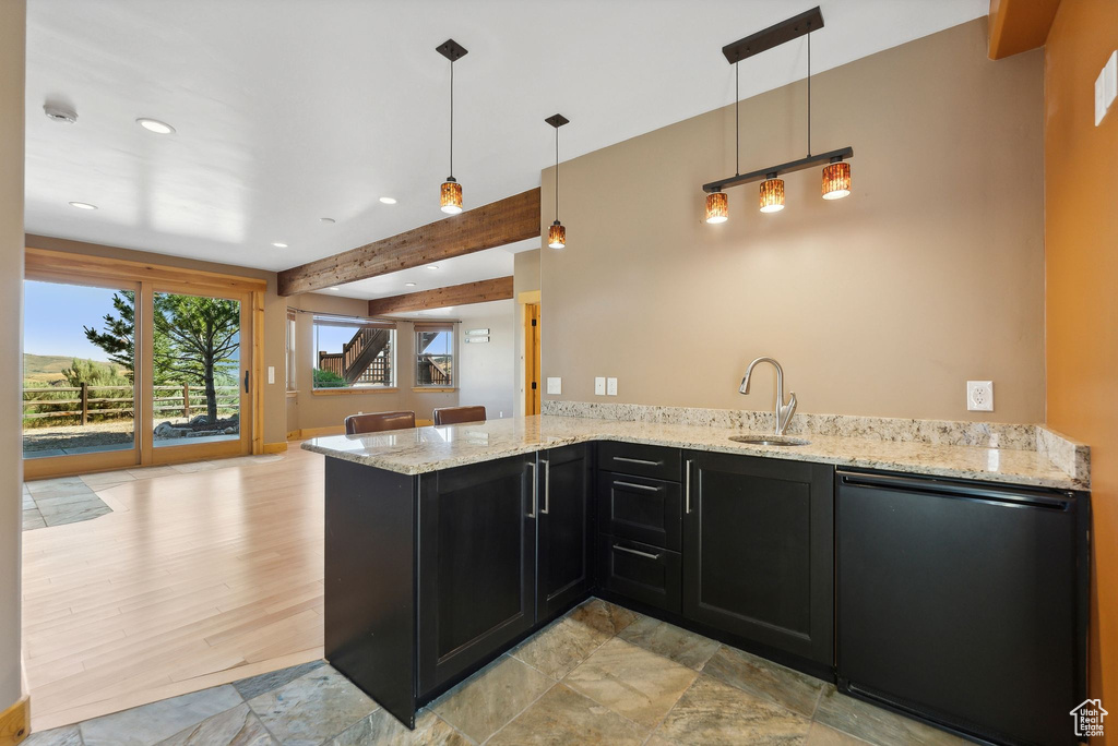 Kitchen with beam ceiling, kitchen peninsula, light hardwood / wood-style floors, pendant lighting, and sink