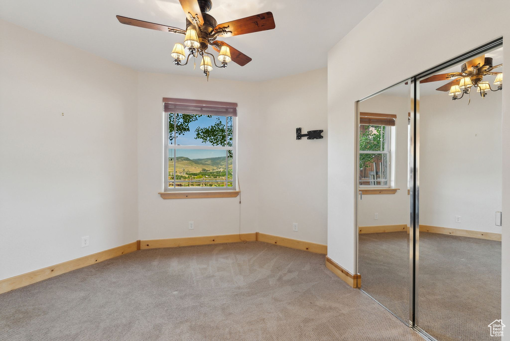 Unfurnished bedroom featuring carpet floors, ceiling fan, and a closet