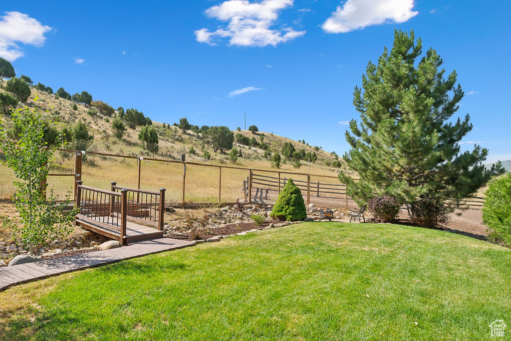 View of yard featuring a deck with mountain view and a rural view