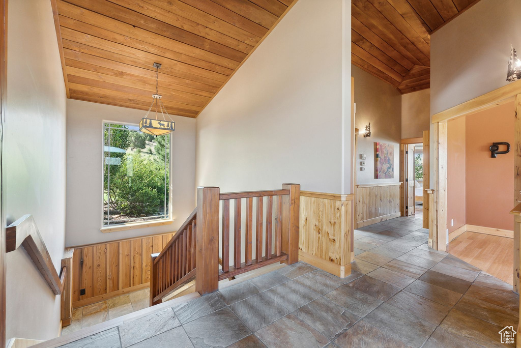 Interior space featuring wood ceiling, high vaulted ceiling, and dark tile patterned flooring