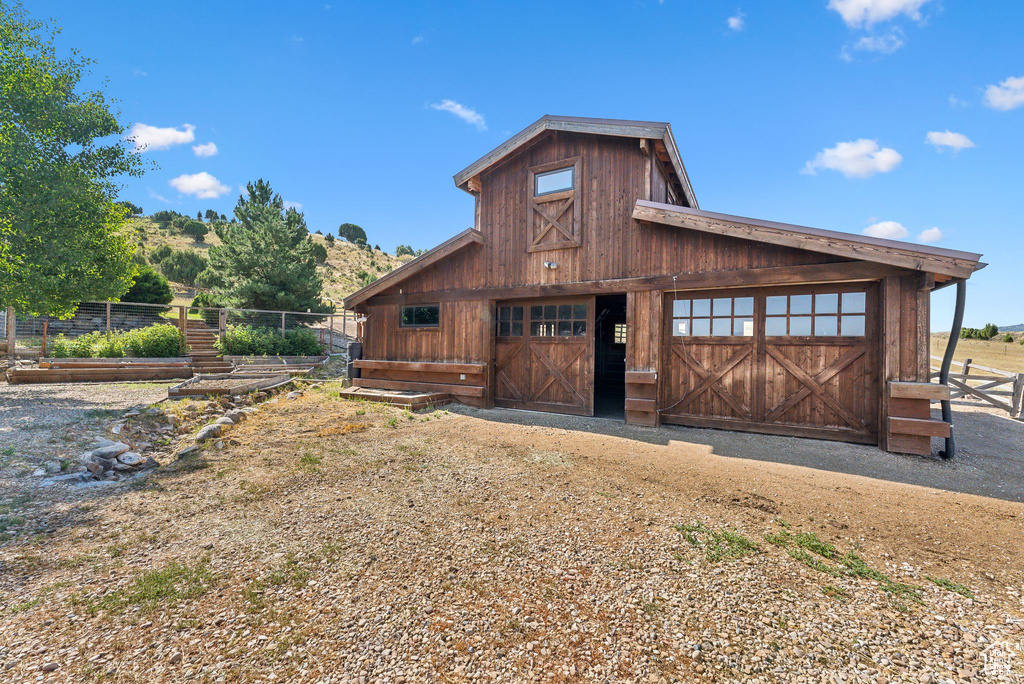 Back of property featuring a garage and an outbuilding