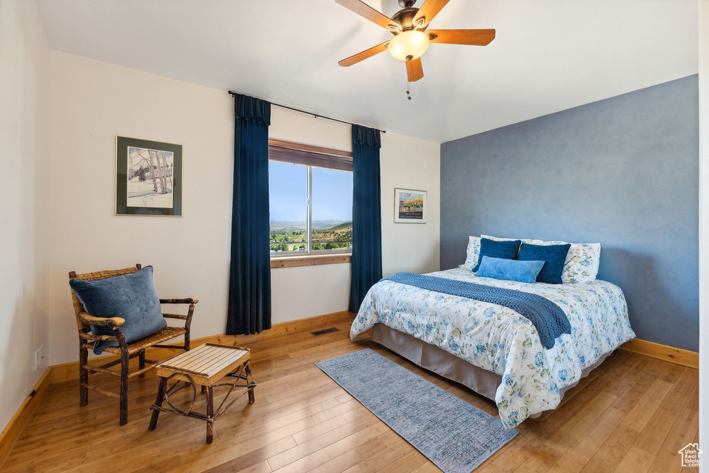 Bedroom with light hardwood / wood-style flooring and ceiling fan