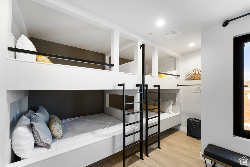 Bedroom with multiple windows and light wood-type flooring