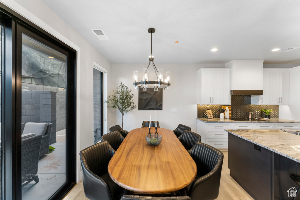 Dining area featuring light hardwood / wood-style floors and an inviting chandelier