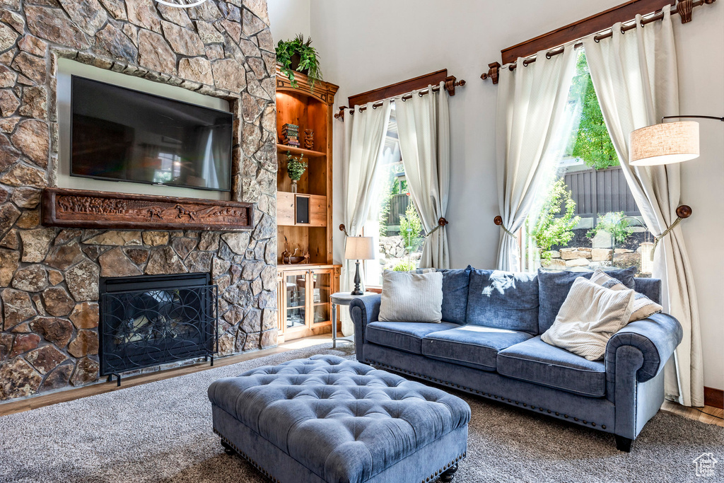 Carpeted living room with plenty of natural light and a fireplace