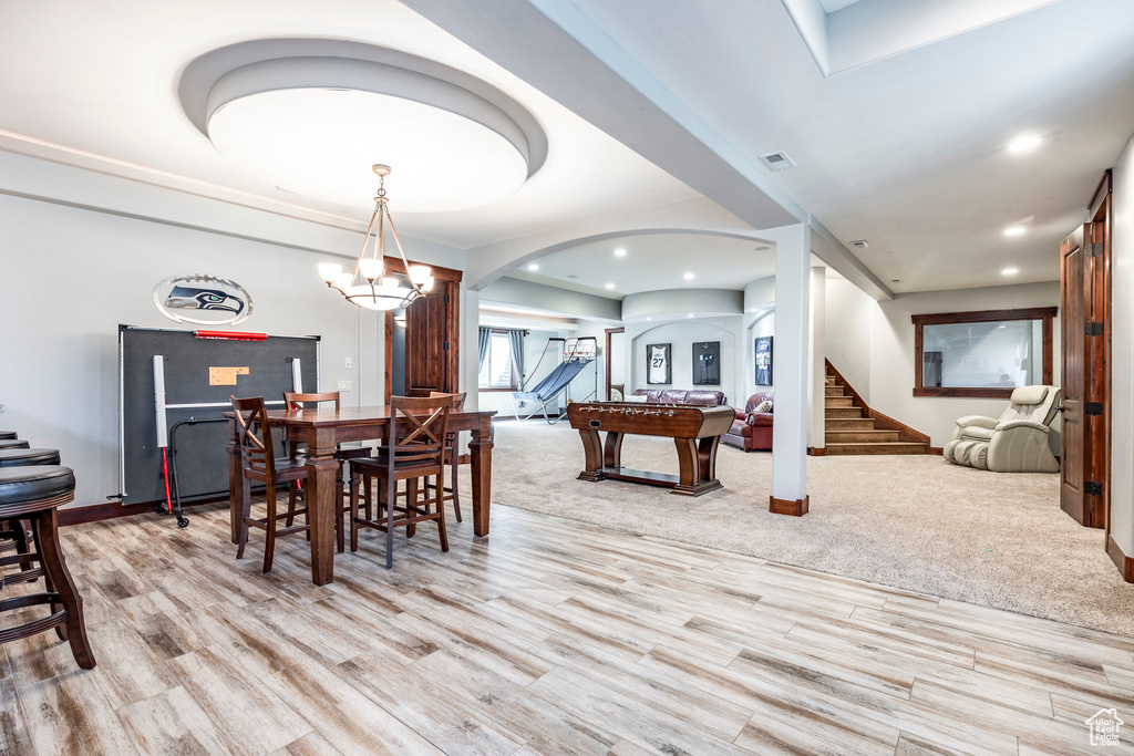 Carpeted dining room with a chandelier