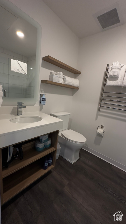 Bathroom with vanity, hardwood / wood-style flooring, and toilet