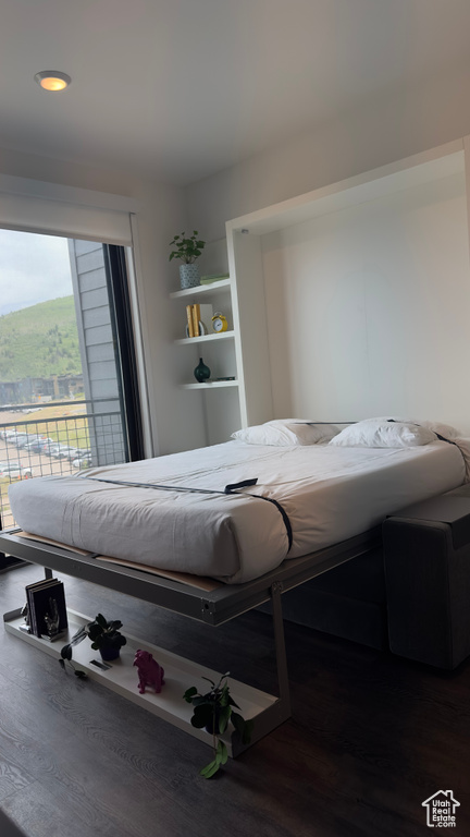 Bedroom with dark hardwood / wood-style floors