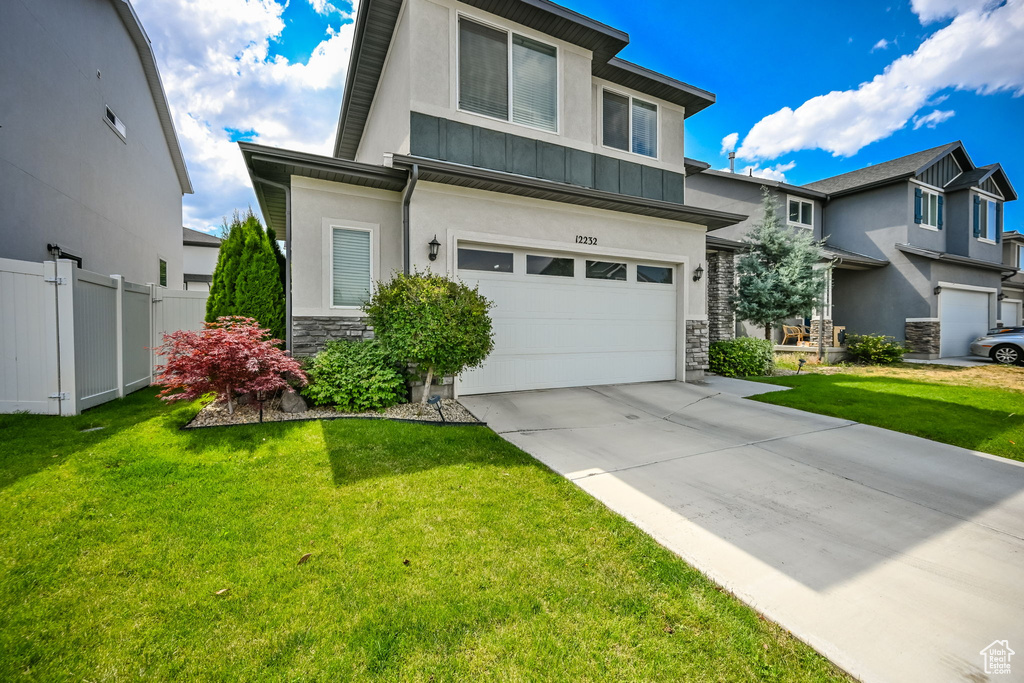 View of front of property with a garage and a front yard