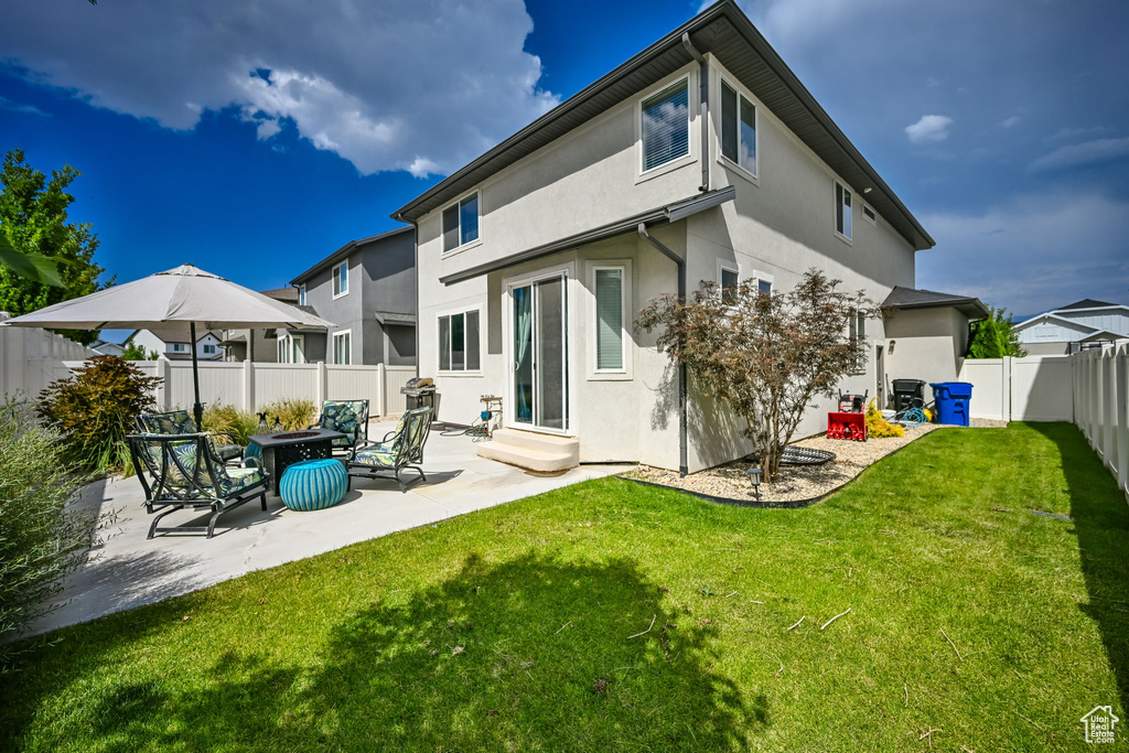 Back of property featuring a patio and a yard