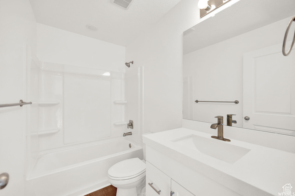 Full bathroom featuring vanity, shower / tub combination, and toilet