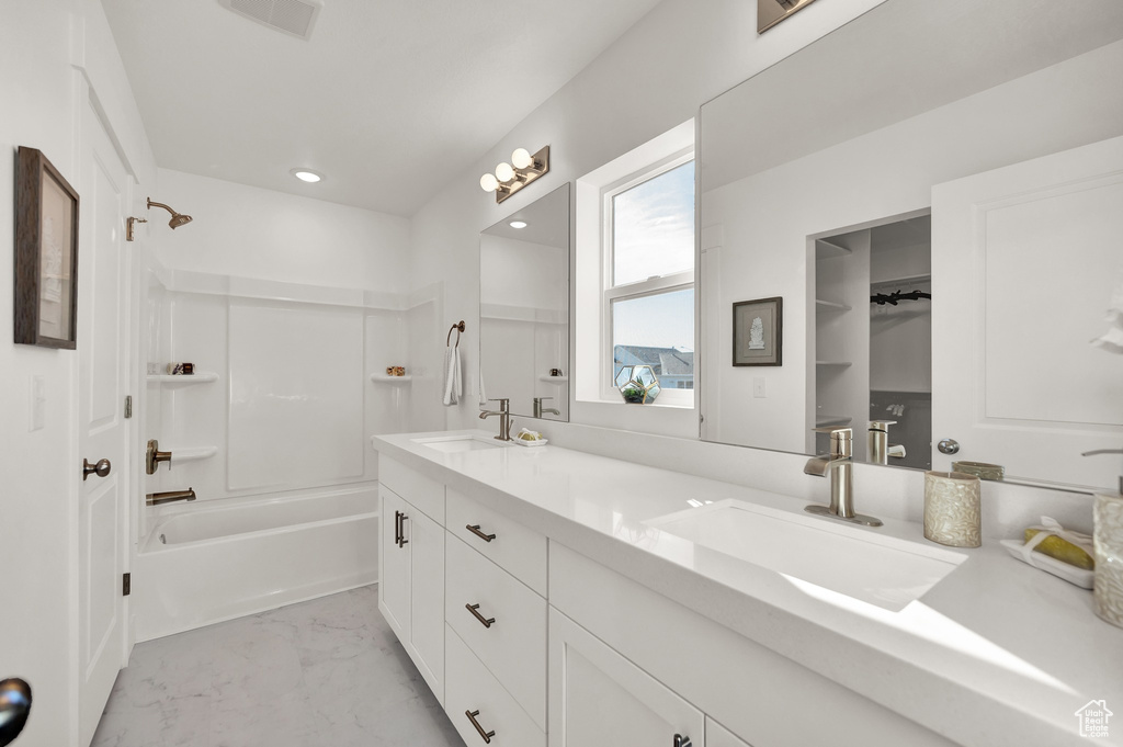 Bathroom featuring shower / bathing tub combination and dual bowl vanity