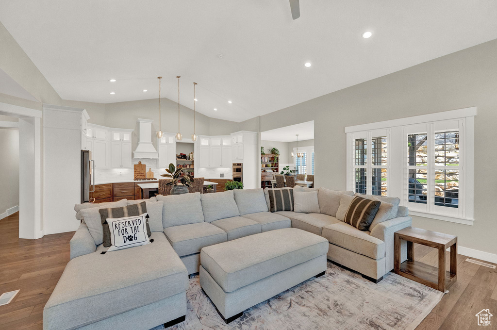 Living room featuring high vaulted ceiling and light hardwood / wood-style floors