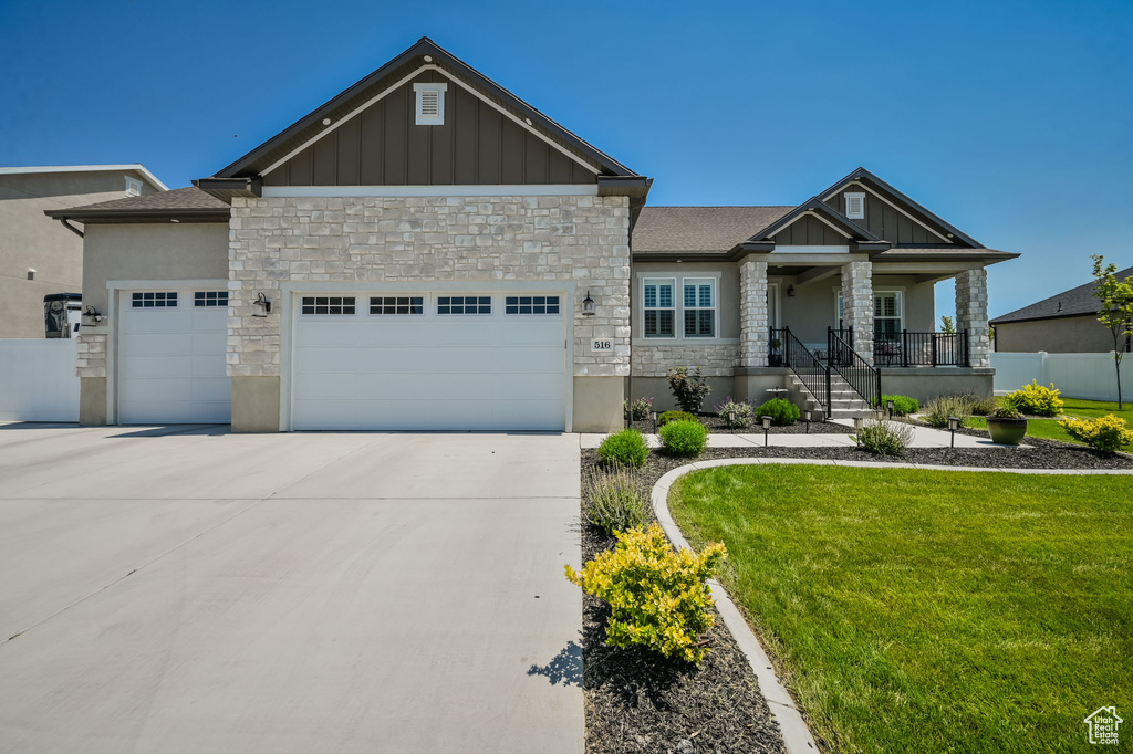 Craftsman inspired home with a garage and a front yard