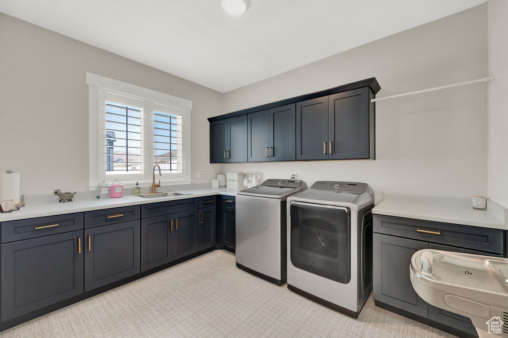 Laundry area featuring cabinets, light carpet, washing machine and dryer, and sink