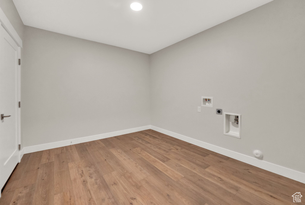 Laundry area with hookup for an electric dryer, hardwood / wood-style flooring, and hookup for a washing machine