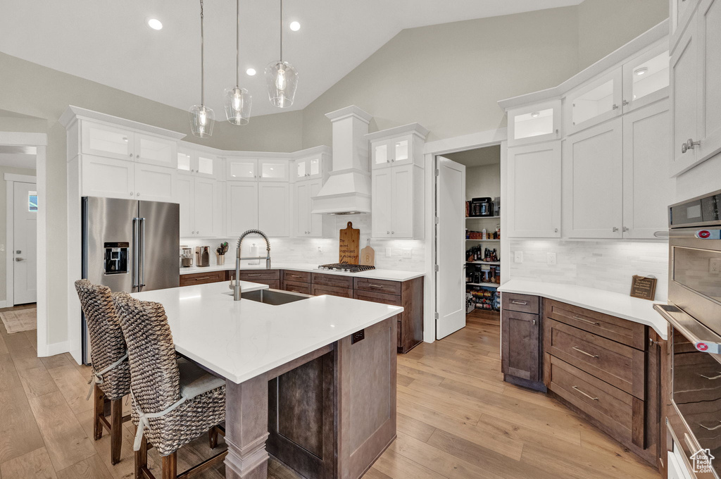 Kitchen featuring appliances with stainless steel finishes, white cabinets, and backsplash