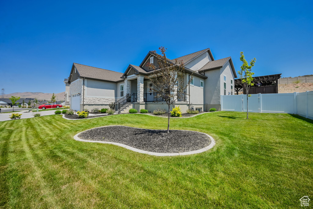 Back of house with a garage and a lawn