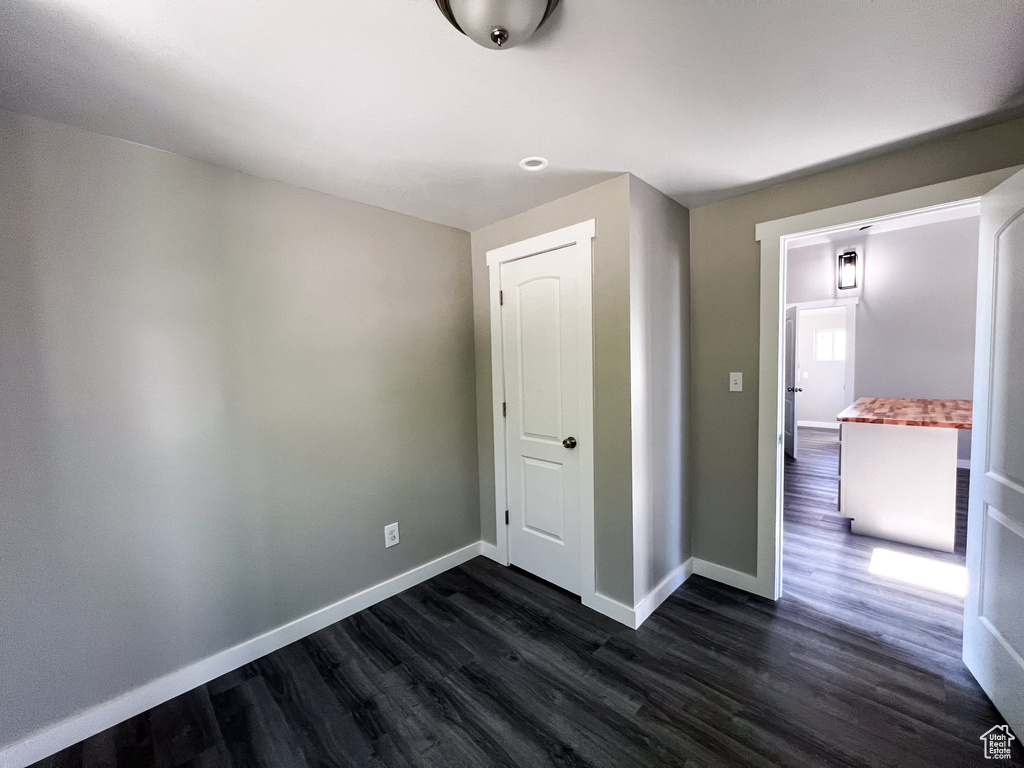 Unfurnished bedroom featuring dark hardwood / wood-style floors