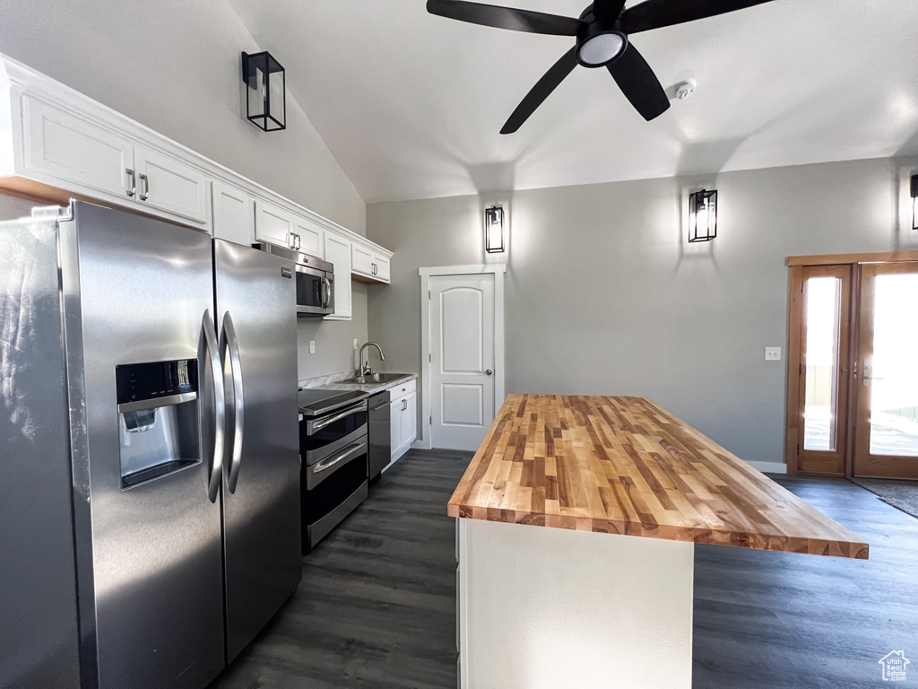 Kitchen with stainless steel appliances, wooden counters, dark hardwood / wood-style floors, white cabinetry, and ceiling fan