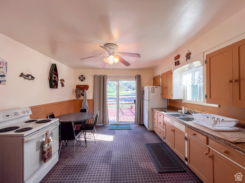 Kitchen with white appliances, sink, and ceiling fan