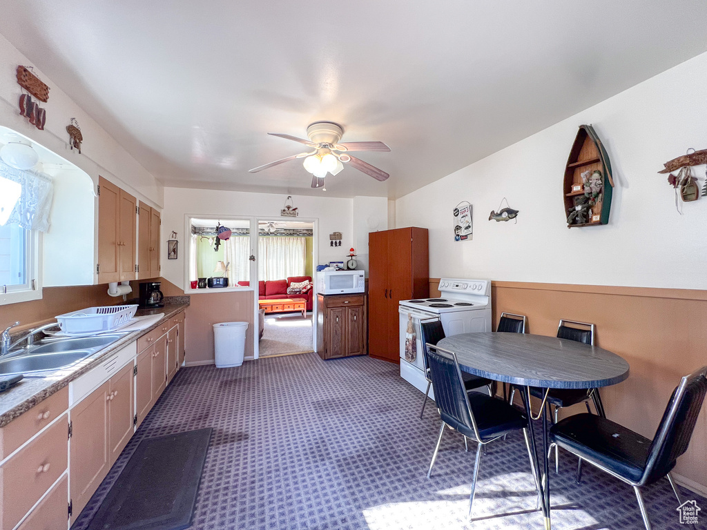 Kitchen featuring sink, ceiling fan, white appliances, and light colored carpet