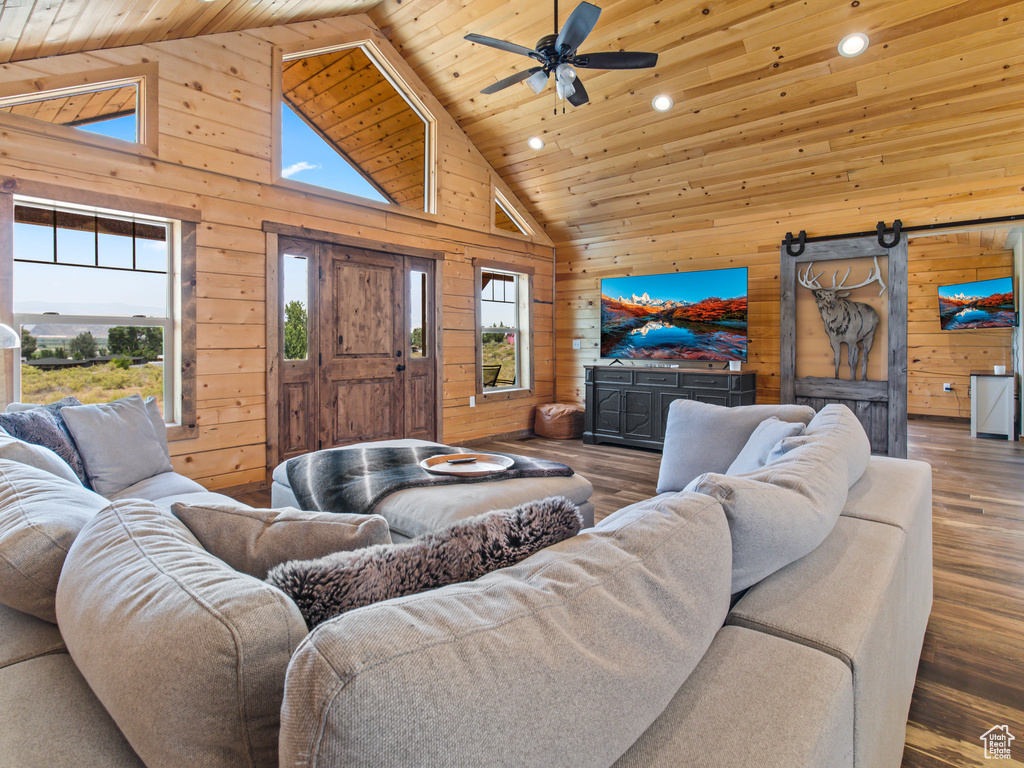 Living room featuring wooden walls, wooden ceiling, hardwood / wood-style flooring, and high vaulted ceiling