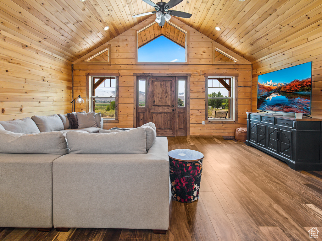 Living room featuring wood walls, ceiling fan, hardwood / wood-style flooring, and wood ceiling