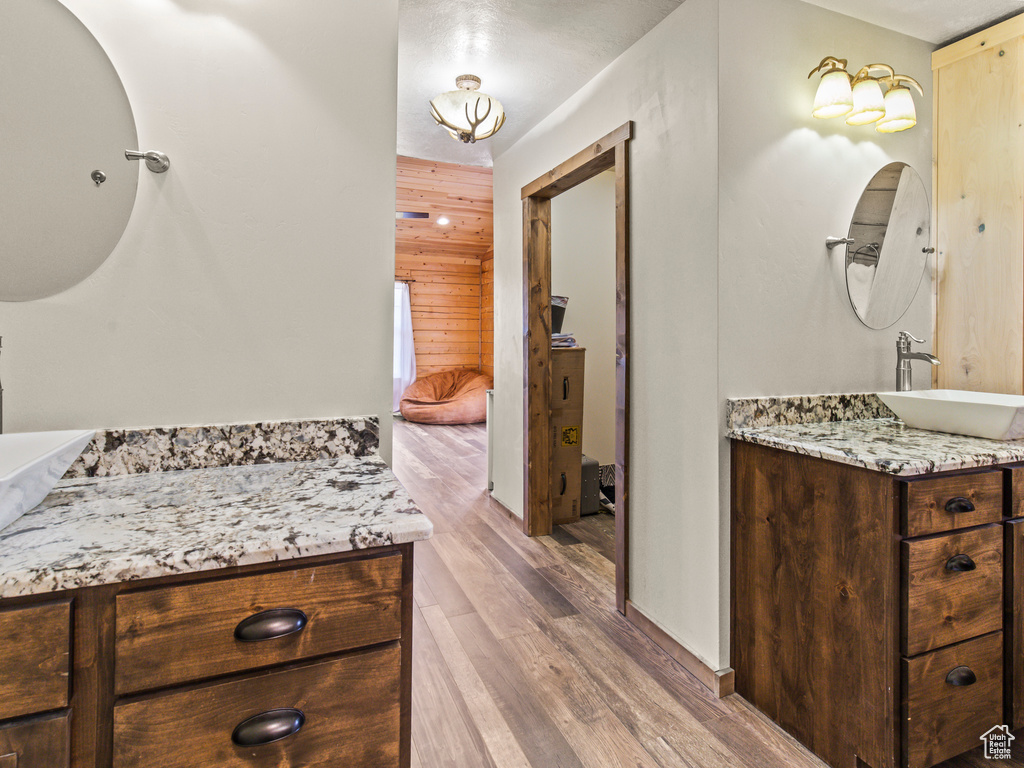 Bathroom with wood-type flooring, wood walls, and vanity