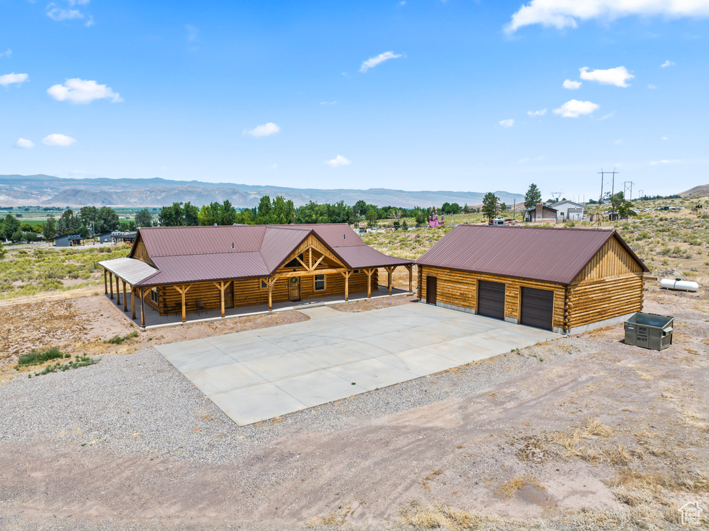 Log cabin with a garage, a mountain view, and an outbuilding